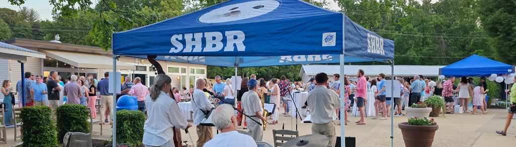 a view of the annual Wine & Cheese party from behind the live band